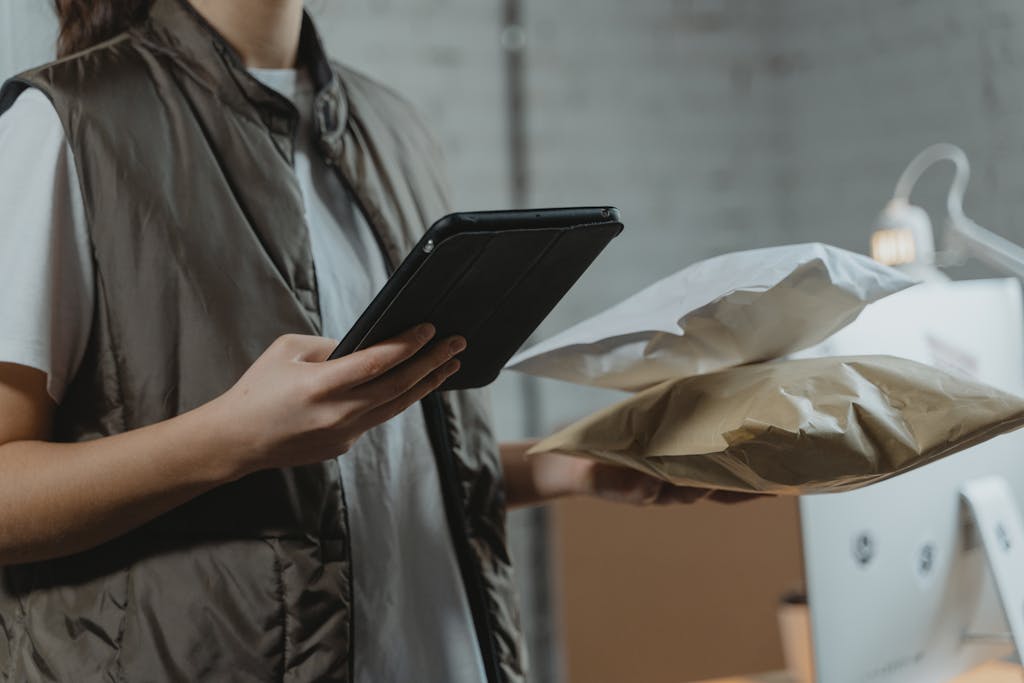 A person using a tablet to manage packages in an indoor setting, highlighting technology and logistics.